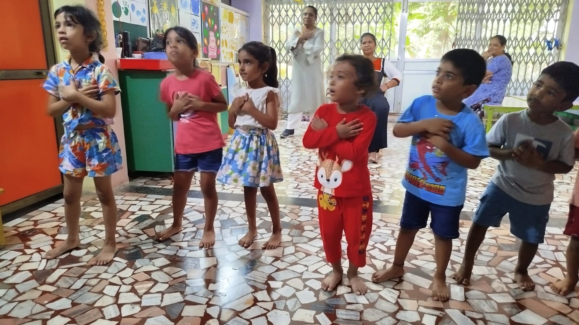 Children singing together inside the Toddlers Nursery classroom