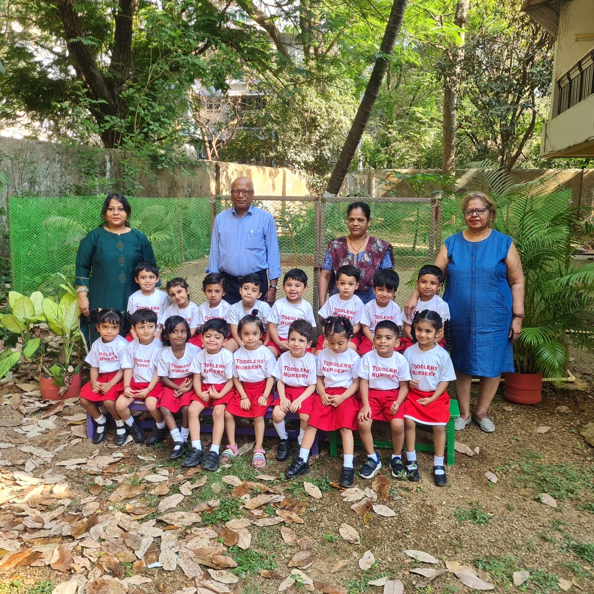 Children and teachers gathered outdoors for a class photo at Toddlers Nursery
