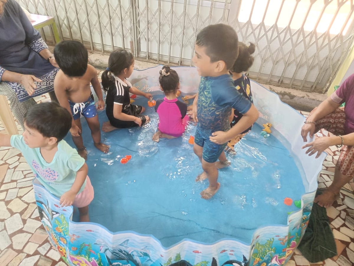 Children enjoying supervised water play in a splash tub