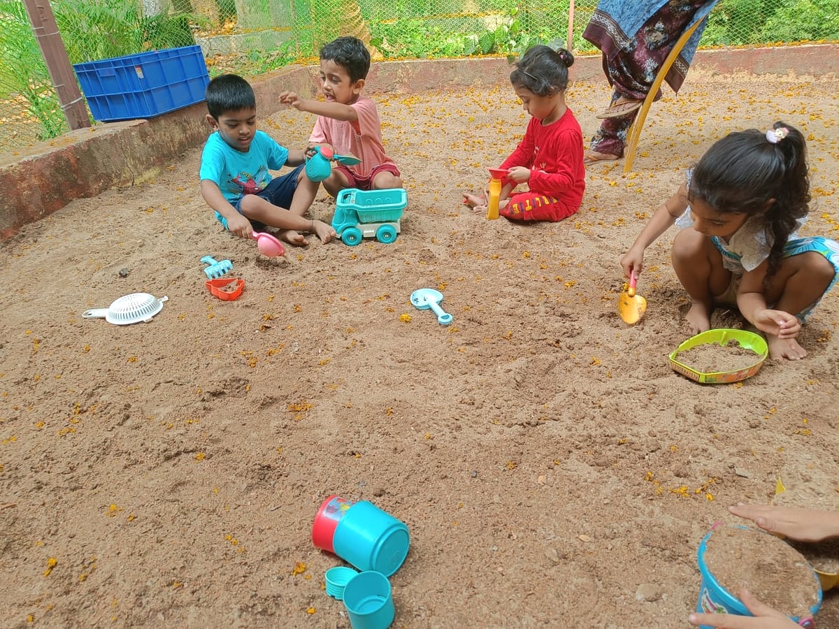 Children enjoying outdoor sandbox play time